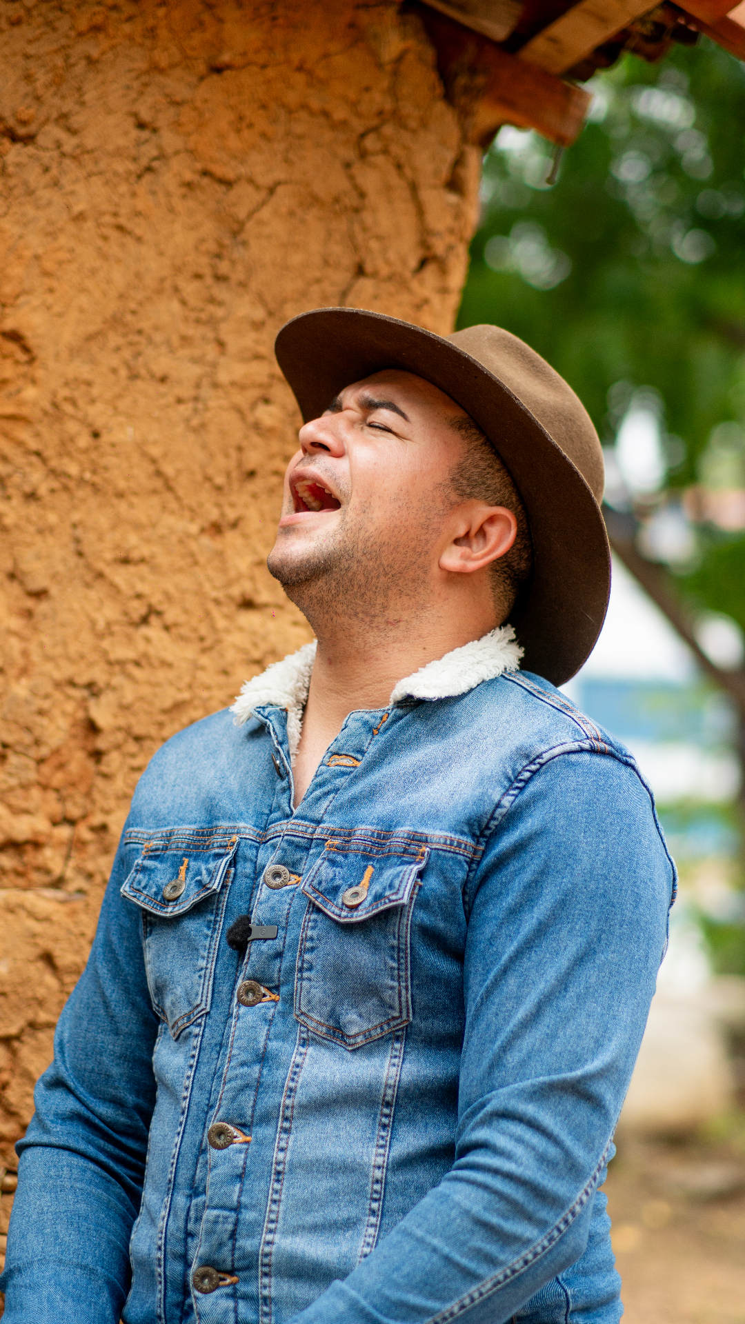 Flávio Villar sorrindo com acordeon em ambiente rústico